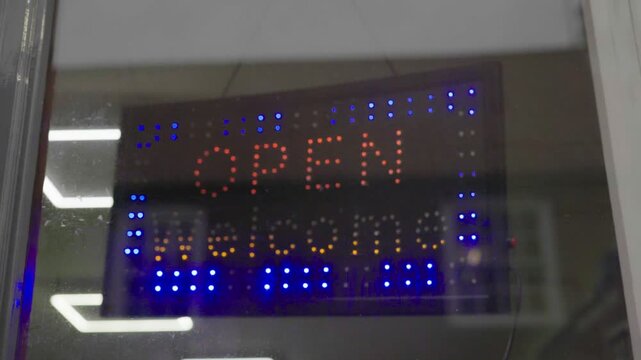 Neon light, open shop sign in window.