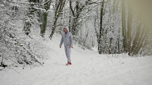 Calm Man Pauses Along Snow Path. Solitary Figure Rests On Frozen Trail. Man Standing Still On Cold Snow Covered Winding Track. Individual Takes Moment To Pause On Icy Winter Walking Route