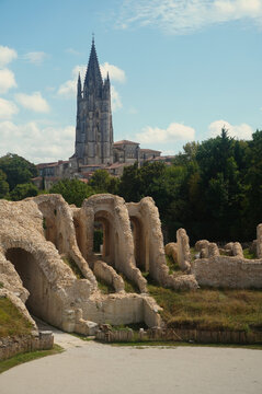 View of the gothic bell tower of Basilique Saint-Eutrope seen from the ancient Gallo-Roman amphitheater in Saintes, France. A unique perspective combining Roman heritage and medieval architecture