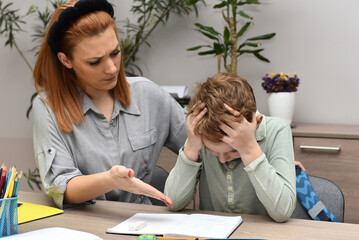 Obraz premium Mother helping frustrated schoolboy with homework at home, emotional support and education concept, stressed child sitting at desk with notebook and pencils, parenting and learning difficulties.