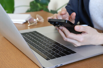 パソコンとスマホを操作する女性の手元 © webbiz