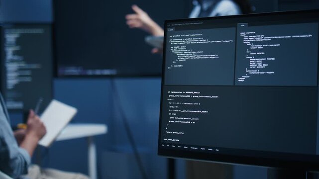 Asian Male developer leading a team meeting, pointing to code on a big monitor while reviewing an AI chatbot module. Concept of collaboration, debugging for coding teamwork in a tech company office.