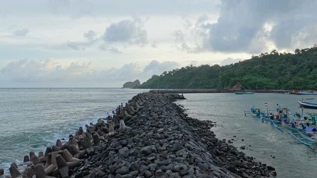 Scenic java indonesia red island beach breakwater and fishing boats