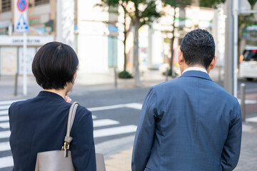 歩道を歩くビジネスマン、ビジネスウーマン