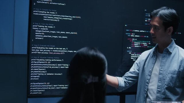 Asian male software engineer presenting source code on large screens in a modern tech office, explaining solutions in a team meeting. Concept for coding, code review, agile workflow.