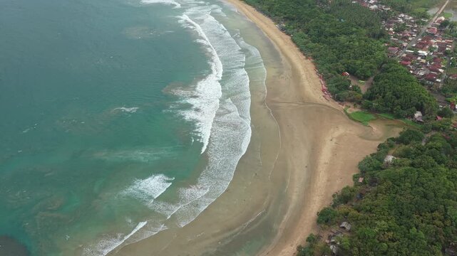 Aerial view of tropical sandy beach and crashing waves in java indonesia