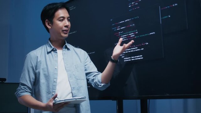 Male software engineer presenting a Coding Task, AI chatbot workflow with code on multiple monitors in a modern office. coding collaboration and agile projects Concept.