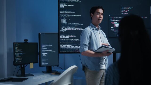 Asian Male Software Developer Presenting Coding on the Screen, Brainstorming and Discussing with Colleagues during Project meeting session in office. collaborating with Team, AI chatbot build Concept.
