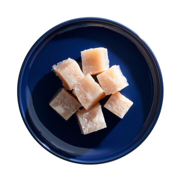 top view of icelandic hakarl fermented shark cubes on navy blue plate