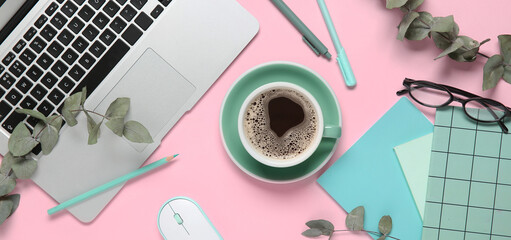 Cup of coffee with laptop, computer mouse, notebooks, eyeglasses and eucalyptus branches on pink background © Pixel-Shot