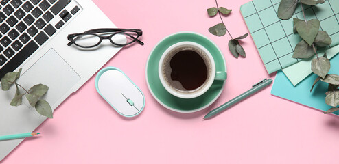 Cup of coffee with laptop, computer mouse, notebooks, eyeglasses and eucalyptus branches on pink background © Pixel-Shot