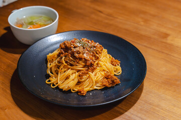 黒い皿のミートソースパスタ