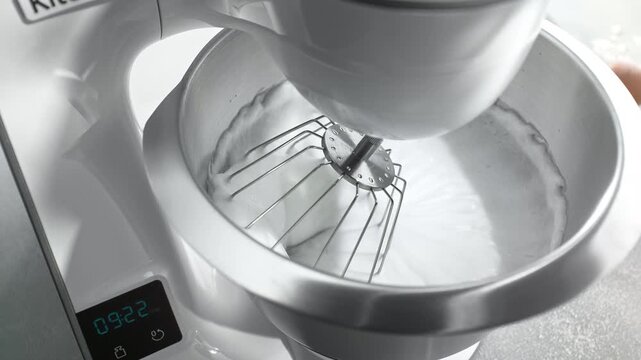 Modern Food Processor Beating Egg Whites to Stiff Peak Stage. Home Cooking in Slow Motion and Macro in a Bright Kitchen