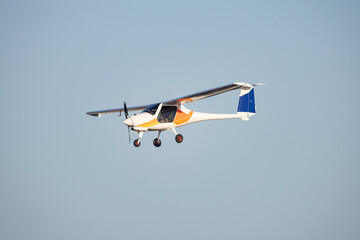Light sport aircraft flying against clear blue sky
