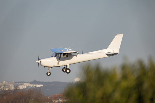 White single engine propeller aircraft flying in blue sky
