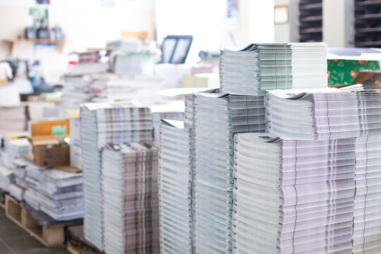 Stacks of printed magazines in commercial print shop. Publishing production, binding, preparation for shipment and distribution.