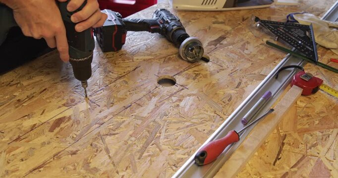 OSB panel hole drilling cordless drill closeup