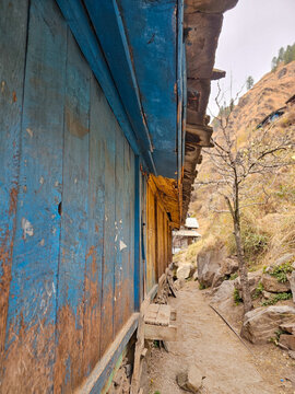 Vertical Perspective of a Weathered Blue Painted Wooden Wall and Porch of a Traditional Himalayan House in Parvati Valley Himachal Pradesh India.