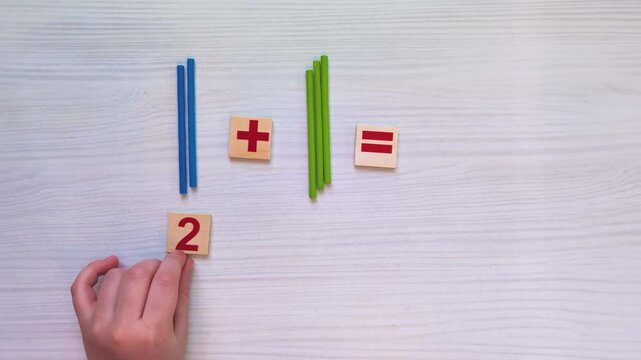 Top view video of children&rsquo;s hands learning to count using colorful math sticks. Educational activity developing early math skills, fine motor coordination, concentration, cognitive growth. Copy space