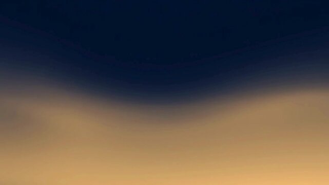 A serene gradient of deep navy blue transitioning into a warm, hazy golden-orange, evoking a sense of twilight or dawn.