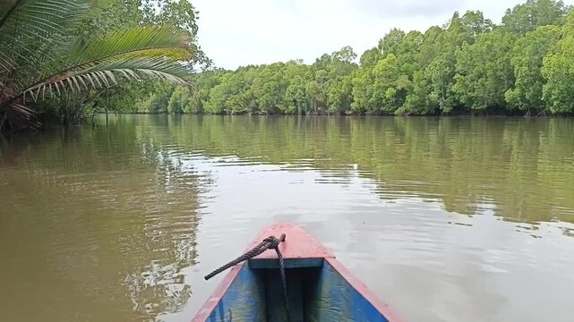 The sampan boat slowly floats on the surface of the salty river water.