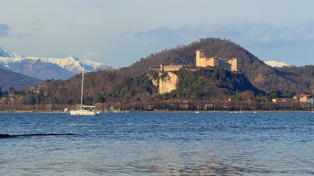 panorama sul lago magggiore con barca a vela e rocca di angera in italia