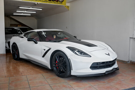 Msida, Malta - February 2, 2026: A sleek white Chevrolet Corvette C7 with black accents and red interior parked inside a car dealership showroom with bright lighting.