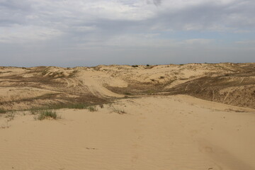 Dramatic clouds above wide sand dunes landscape