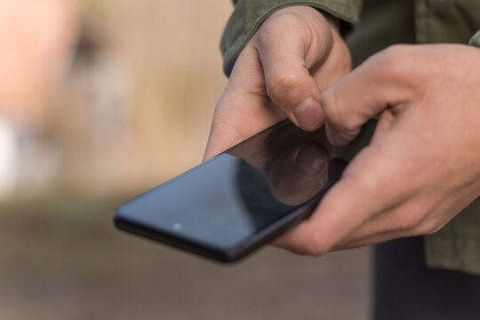 Close-Up of Person Holding Used Mobile Phone Indoors