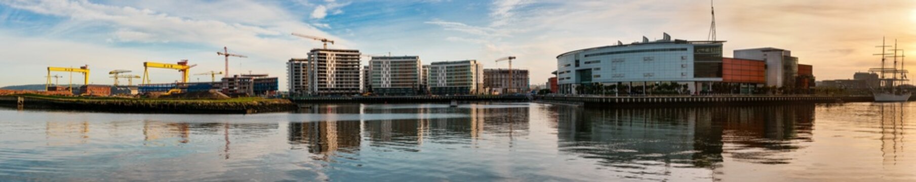 Panorama of Belfast Titanic Quarter, with Harland and Wolff cranes, and the Odyssey Arena. Lagan in foreground.