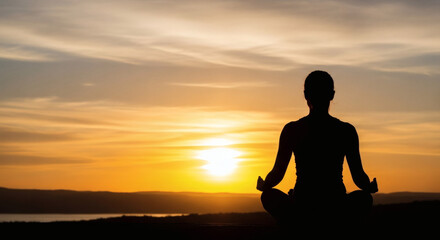 Silhouette of a person practicing yoga and meditation in the lotus position against a stunning golden sunset, embodying peace, tranquility, and mindful living