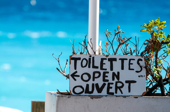 Sign indicating that seaside toilets are open in French and English: "Toilettes open ouvert"
