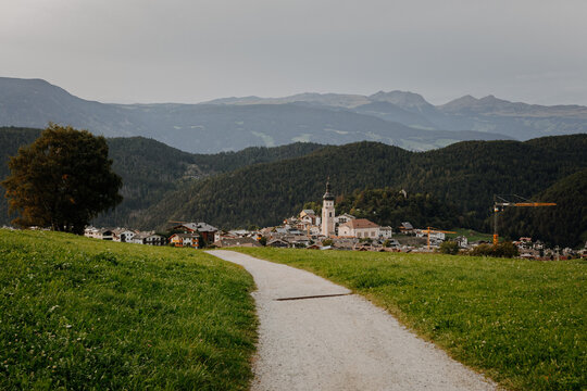 Scenic gravel hiking path leading down to the alpine village of Siusi allo Sciliar in South Tyrol, Italy