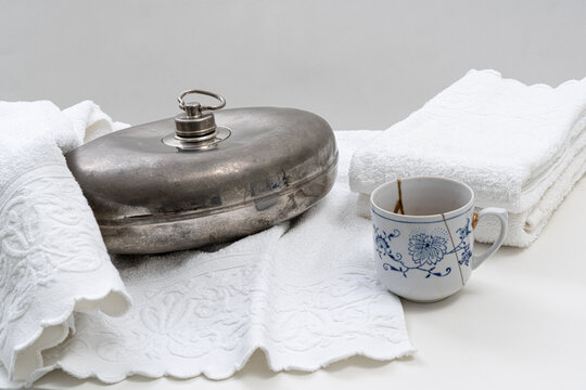 Metallene Bettflasche mit Frottee T&uuml;cher und Tasse Tee