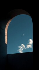 Fototapeta premium Crescent moon and scattered white clouds visible through a dark architectural archway