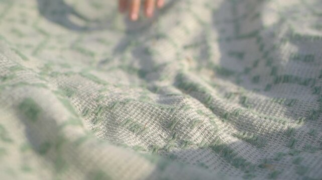 Slow living picnic setup with a green patterned blanket in a rural meadow