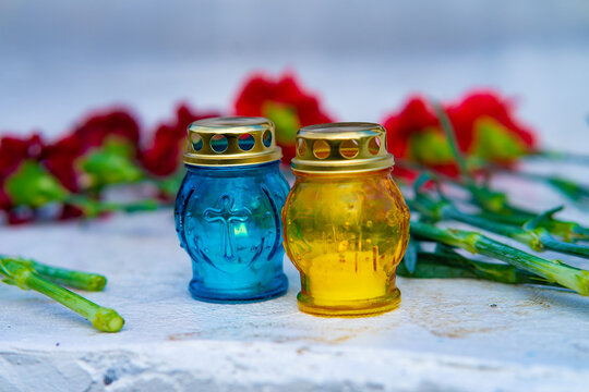 Memorial Blue and Yellow Candles with Red Carnations for Remembrance Day in Ukraine