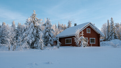 Nestled in the serene landscapes of Akaslompolo, this charming red cottage is surrounded by snow-covered trees. A peaceful winter scene captures the beauty of Lapland, perfect for holiday getaways.