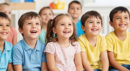 Obraz premium Smiling children sitting together in classroom looking up with joyful expressions