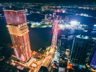 Aerial night view of Ho Chi Minh City skyline with glowing skyscrapers and neon lights, Drone panorama of Saigon downtown, illuminated towers and busy streets of vibrant city
