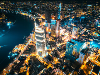 Aerial night view of Ho Chi Minh City skyline with glowing skyscrapers and neon lights, Drone panorama of Saigon downtown, illuminated towers and busy streets of vibrant city