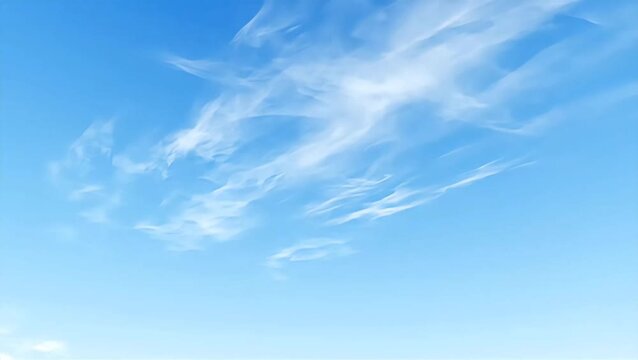 Wispy white clouds drift across a vast expanse of bright blue sky on a clear day, evoking a sense of peace and openness