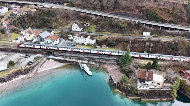 Aerial view of multimodal transportation with passenger train passing near docked boat and road traffic, modern mobility concept