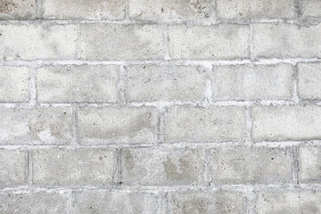 Fototapeta premium Gray concrete block wall texture background. Rough cement surface with joints and weathered stains. Industrial masonry pattern for construction, architecture, renovation and urban exterior design.