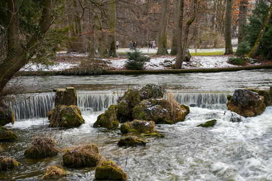 Small artificial waterfall in the Eisbach, English Garden in Munich in winter.