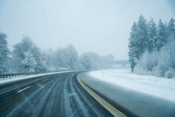 Snow flurries on the highway. The wintry A8 highway near Munich with snow-covered road and...