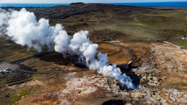 Aerial view of geothermal area in Iceland with steam vents and hot springs surrounded by colorful mineral terrain