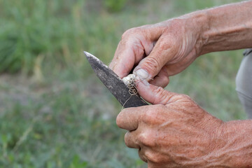 The man has harvested garlic and immediately peels it for further consumption.