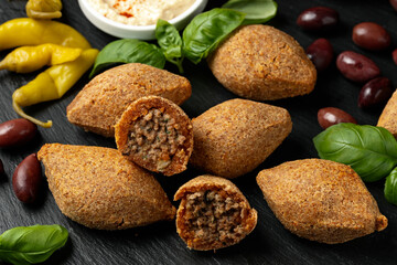 Delicious Arabic food, kibbeh on black stone board. Middle Eastern cuisine