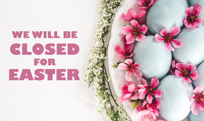 Signboard with the inscription We will be closed for Easter. Pastel blue Easter eggs on a white...